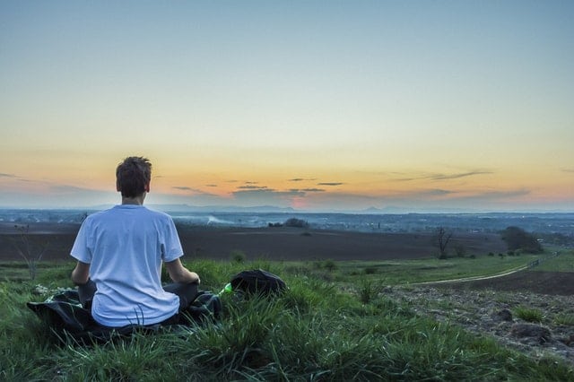 Person meditating on a cliff