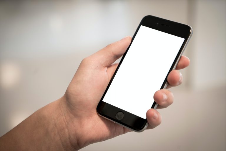 Man holding iPhone with a white screen.