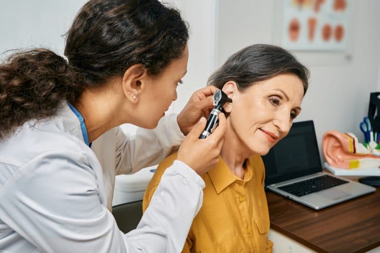 Audiologist performing a hearing exam on a female patient.