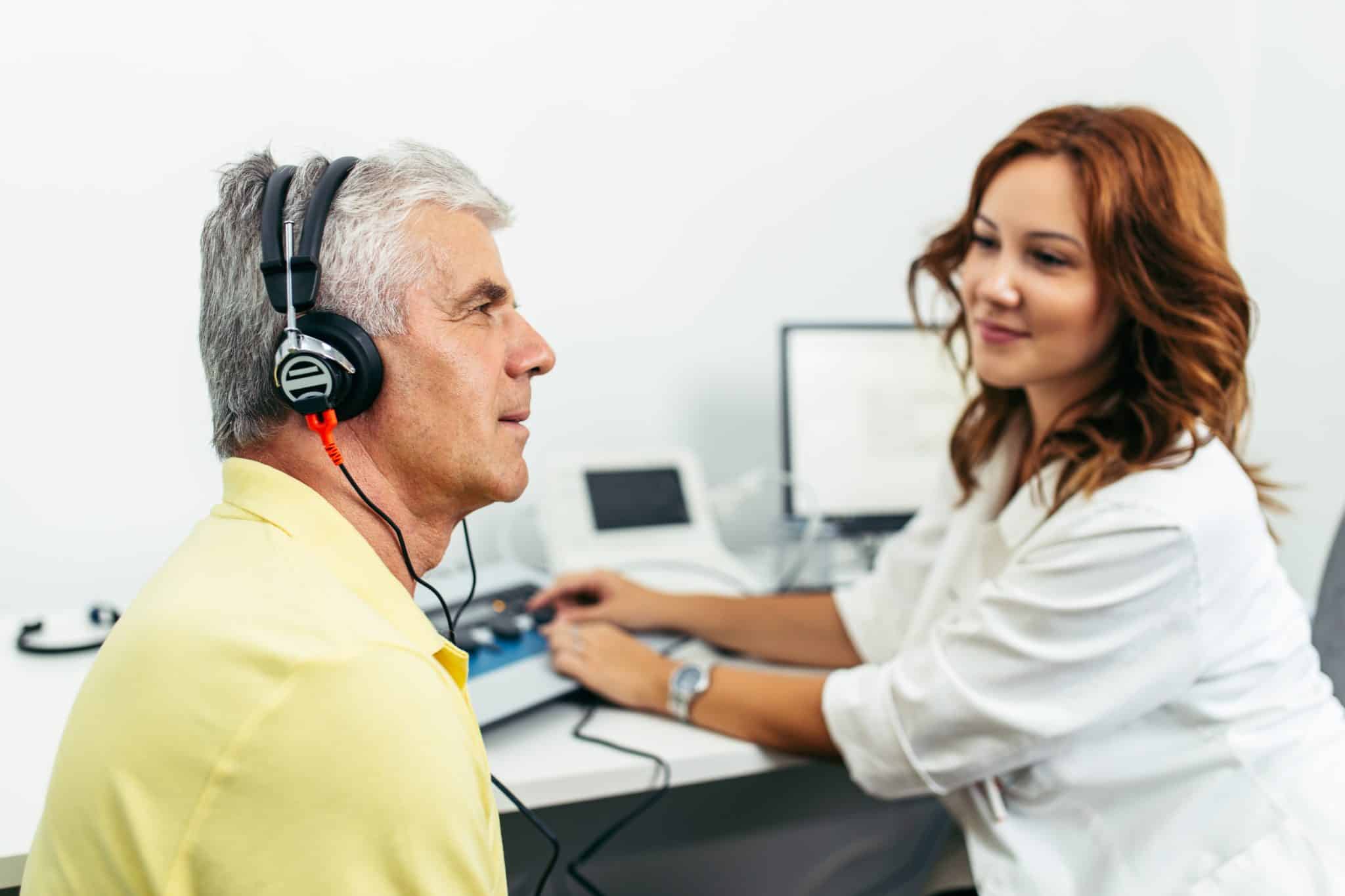 audiology patient completing hearing test Patient with headphones on gets tested for hearing loss by a hearing care provider