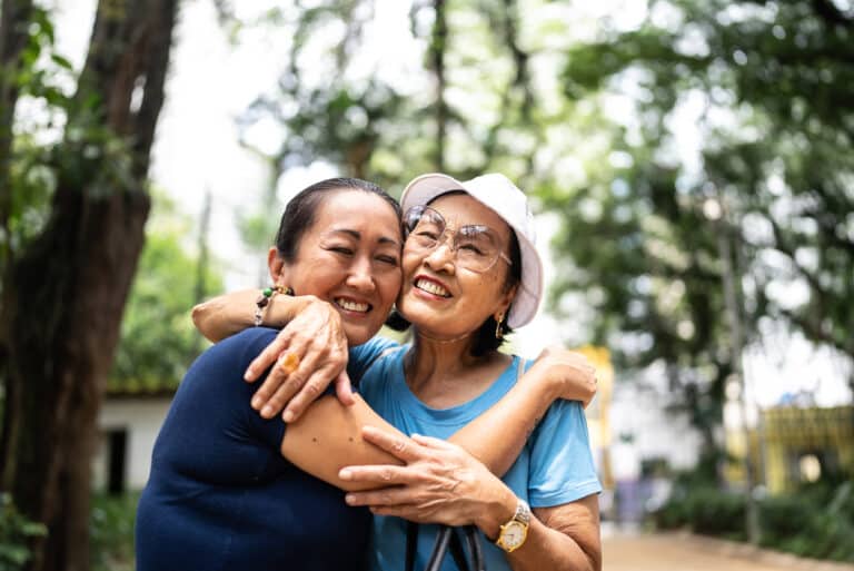 Two women hugging, looking happy