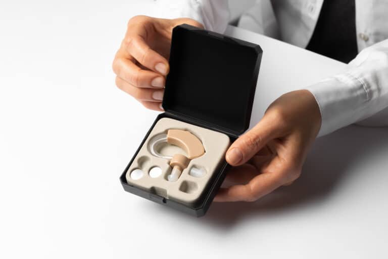 Doctor presenting a hearing aid in a box