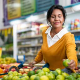 Woman buying limes at the grocery store