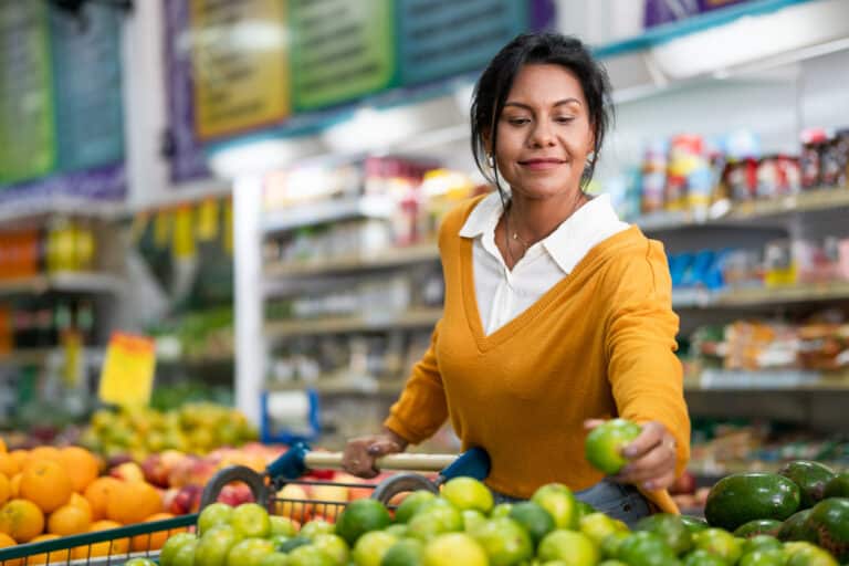 Woman buying limes at the grocery store