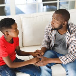 Father and son having a conversation on the couch