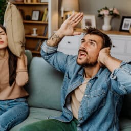 A couple covering their ears to block out noise