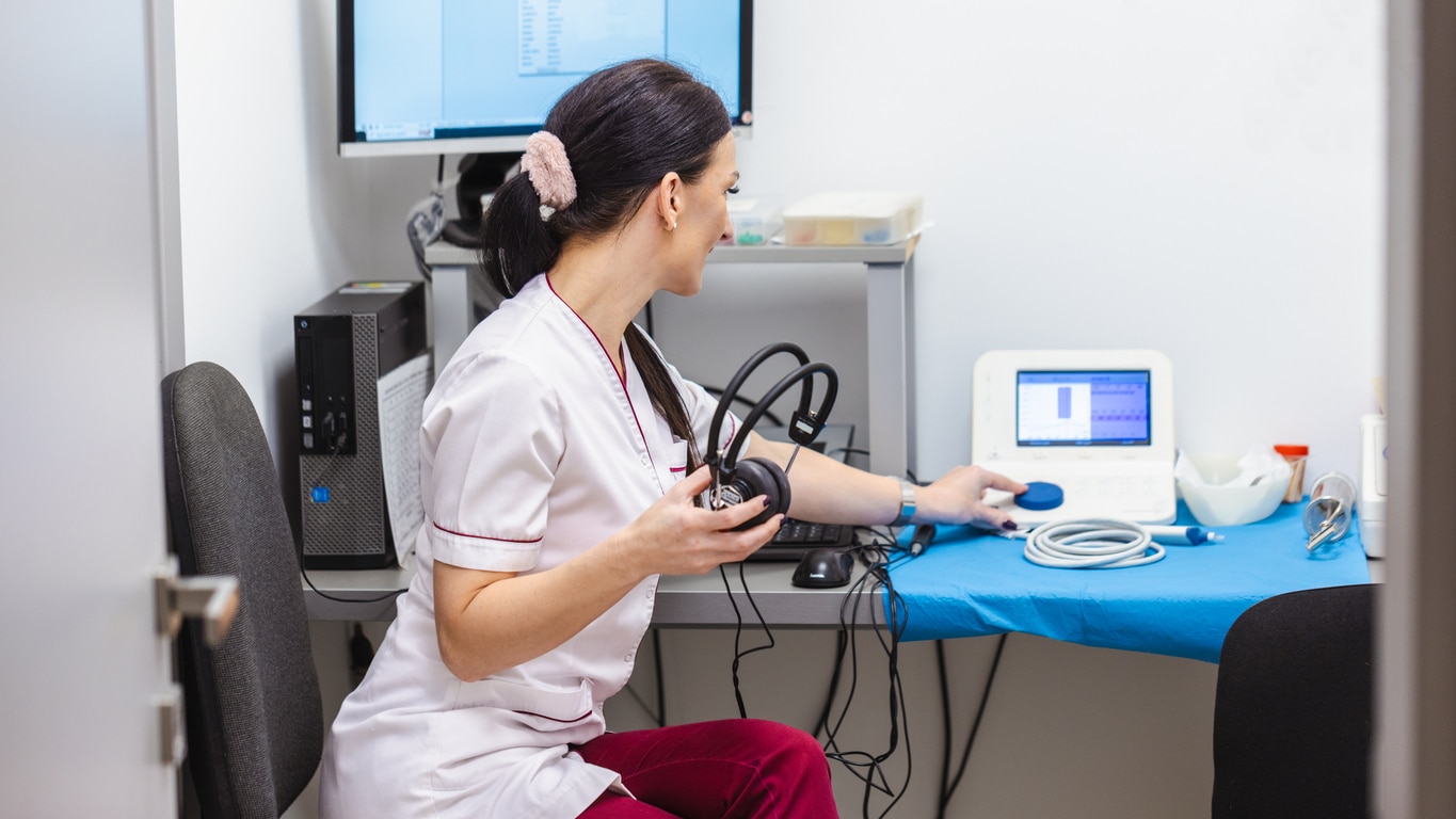 Audiologist preparing her equipment for a hearing evaluation
