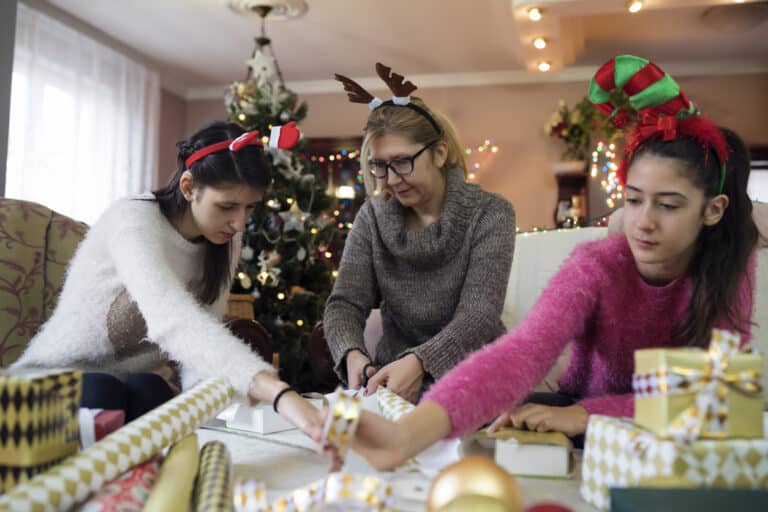 Family wrapping presents together; one child wears smart hearing aids. Family wrapping presents together; one child wears smart hearing aids.